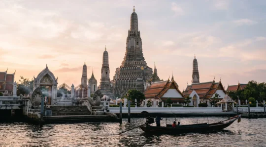 Silhouette dorée d'un temple bouddhiste ancien au bord du fleuve Chao Phraya à Bangkok, symbole de l'héritage du royaume de Siam